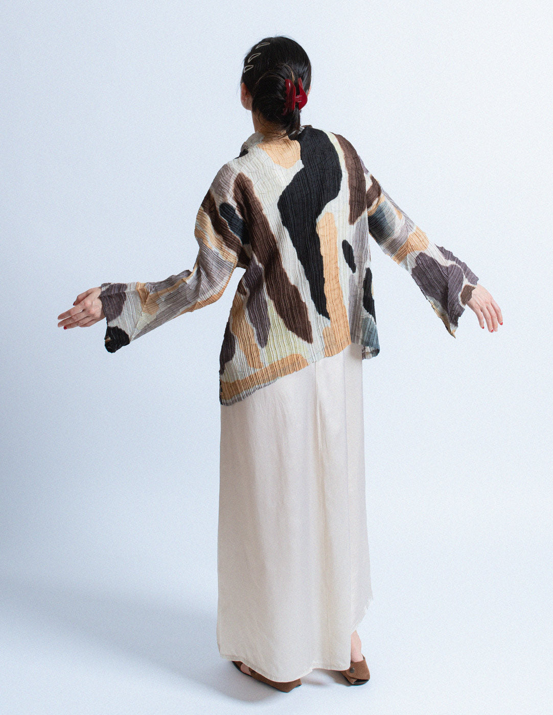 Issey Miyake earth tone pleated cardigan with abstract painterly pattern back view