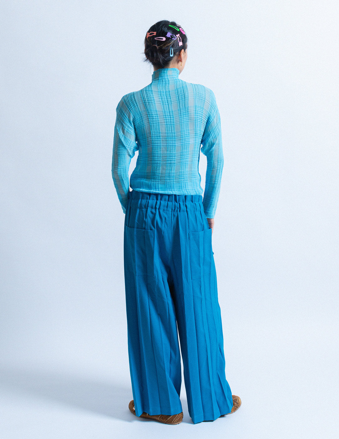 Issey Miyake blue pleated trousers back view